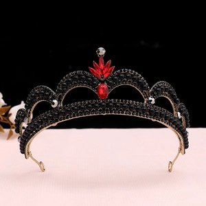 Close-up of vintage baroque crown featuring black beads and a central red gemstone