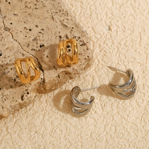 Detailed view of intertwined C-shaped earrings in 18K gold and silver stainless steel