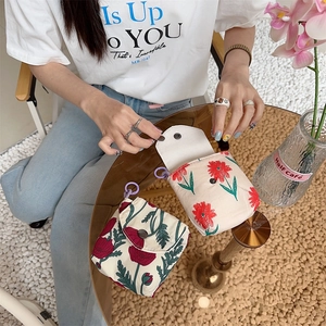 Close-up of portable floral fabric storage pouches with cream fabric and red flower patterns