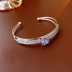 Detailed view of silver camellia cuff bracelet with rows of sparkling zircon stones