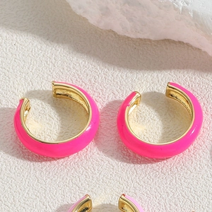 Detail of fuchsia enamel C-shaped ear clip with gold plating and vibrant summer finish