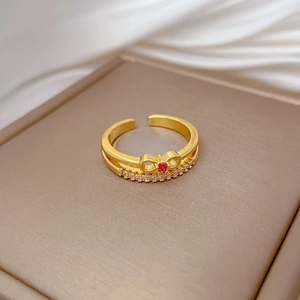 Detail of gold bow ring with red heart gemstone and diamonds in a jewelry box