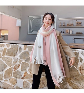 Close-up of pink and white color-block knit scarf with tassel detail and NPC ARG label