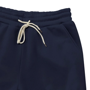Détail du pantalon de survêtement bleu marine avec taille élastique et cordon blanc