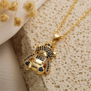 Macro shot of bear pendant with blue crown and black crystals on gold O-chain