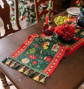 Detail of jacquard Christmas table runner with tassels and woven festive patterns