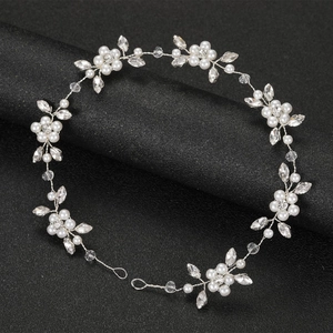 Elegant silver bridal headpiece with white pearls and sparkling crystals on black background