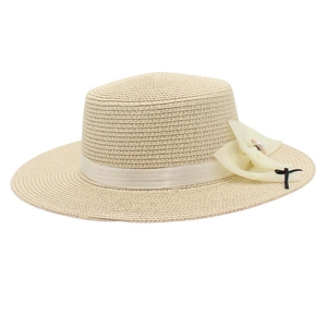 Close-up of cream woven straw hat with chiffon bow, pearl center and fine black ribbon