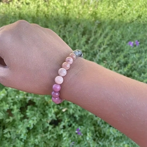 Macro detail of 8mm pink gradient natural stone beads on an elastic beaded bracelet