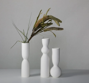 Detail of matte white ceramic vases with horizontal spiral texture in Nordic minimalist style