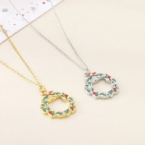 Detail of gold and silver Christmas wreath necklaces with green enamel and clear crystals
