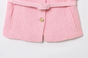 Detail of pink tweed texture with decorative golden button and matching fabric belt