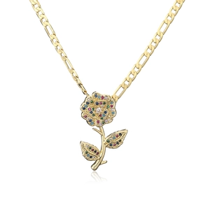 Detailed macro view of 18K gold Figaro chain featuring a colorful zircon rose pendant