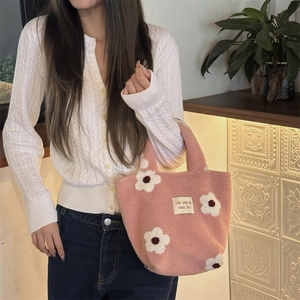 Close-up of pink plush handbag with 3D white flower motifs and sozakka beauté label
