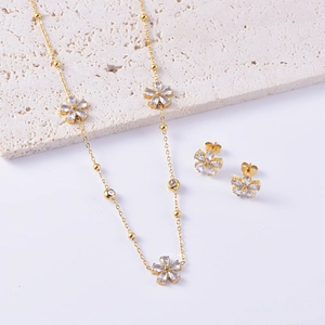 Close-up of gold flower necklace and earrings set with sparkling cubic zirconia