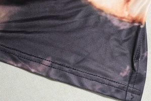 Detail shot of double-row hem stitching on black and purple angel print top