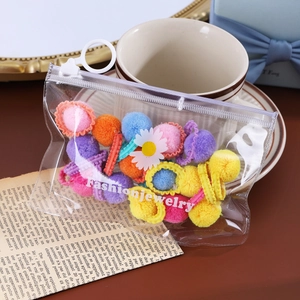 Détail d'élastiques à cheveux en peluche colorés avec breloque marguerite en pochette