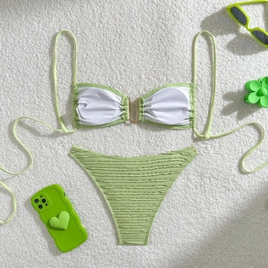 Flat lay of textured lime green bikini with gold U-ring detail and ribbed fabric texture