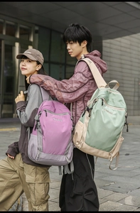 Outdoor backpacks in purple and green colors shown in a lifestyle street view setting