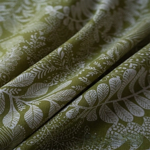 Detailed macro view of green cotton linen fabric with white leaf prints and fringe
