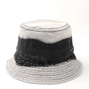 Détail d'un chapeau bob en jean avec dégradé, bords surpiqués et étiquette métallique