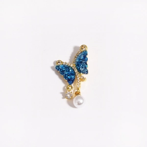 Detailed view of butterfly pendant with blue wings, sparkling zircons and a pearl drop