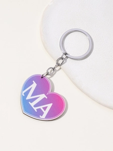 Detail of heart-shaped keychain with purple-blue gradient and printed MA letters