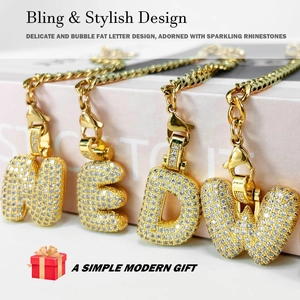 Detail showing shiny gold bubble letter charms with rhinestones and cuban chains