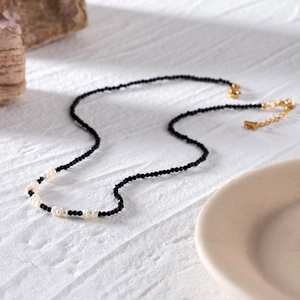 Collier élégant en acier inoxydable plaqué or 18k avec cristaux noirs et perles blanches