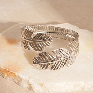Macro detail of silver leaf texture and metallic finish on an open cuff bracelet