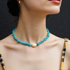 Detail of vintage turquoise gravel necklace with white pearl and gold spacer beads on neck