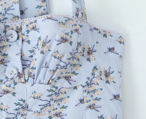 Close-up of light blue floral dress with sweetheart neckline and decorative buttons
