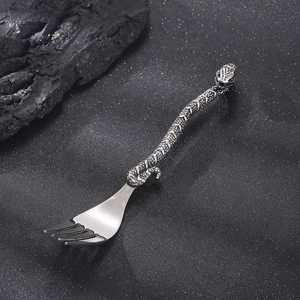 Close-up of vintage silver stainless steel fork with creative snake-shaped handle carving
