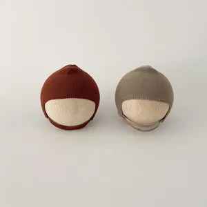 Minimalist knit baby earflap hats in caramel and beige colors for winter warmth