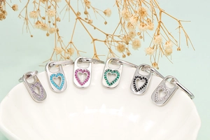 Macro view of heart-shaped pendants with colorful crystals and silver metal base