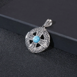 Macro shot of silver titanium steel pendant with turquoise inlay and Celtic cross detail