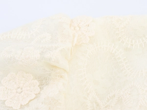 Gros plan de la broderie florale et de la dentelle ondulée sur le tissu de la robe