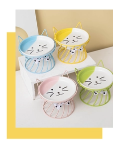 Detail of four colorful ceramic cat bowls with decorative cat ears on metal stands
