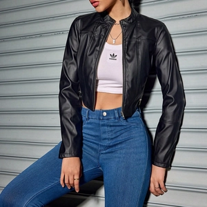 Detail of a black cropped PU jacket featuring a stand collar and metallic zipper texture