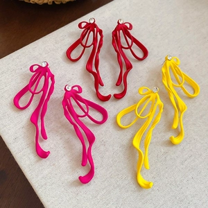 Macro detail of matte abstract ribbon earrings with colorful finish and zircon stud