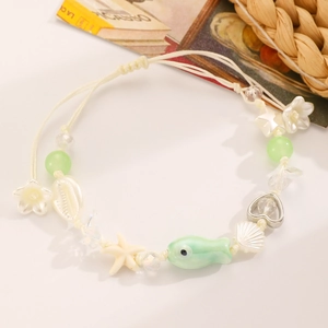 Dettaglio della collana bohémien con pesce in ceramica, stella marina e conchiglia