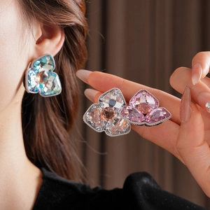 Detail of diamond-studded flower stud earrings in blue, white and pink crystal colors