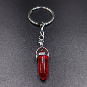 Detail of red crystal hexagonal pillar pendant on a silver metal keychain ring