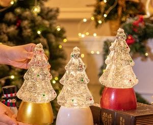 Detailed view of glowing crystal Christmas tree music boxes in gold, white and red colors