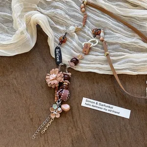 Vue détaillée de pendentifs fleurs bohèmes avec médaille Believe et perles variées