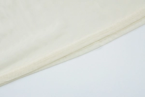 Detailed close-up of cream mesh fabric showing breathable texture and fine stitching