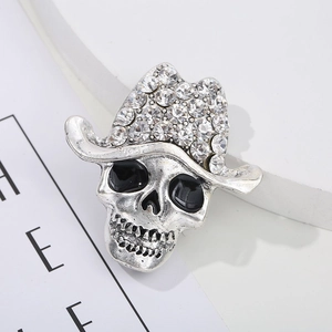 Macro detail of retro silver skull brooch with crystal cowboy hat and black enamel eyes