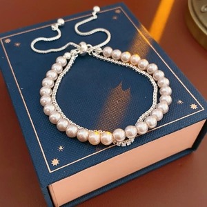 Détail macro du bracelet double rangée en perles et zircons avec fermoir coulissant réglable