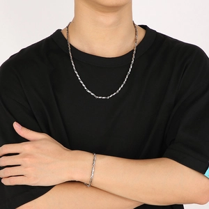 Close-up of silver Mobius loop necklace and twisted chain bracelet set on model
