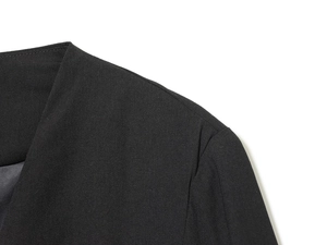 Close-up of lapel and shoulder tailoring on a black blazer dress with premium texture
